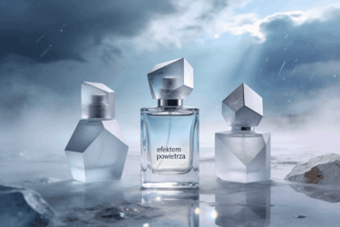 Kompozycja przedstawia minimalistyczne flakony perfum o geometrycznych kształtach, wykonane z przezroczystego i lekko matowego szkła, umieszczone w chłodnej, przestrzennej scenerii. Tło abstrakcyjne, inspirowane świeżym powietrzem po burzy: delikatna mgła, subtelne refleksy światła, wrażenie ruchu powietrza i przestrzeni. Kolorystyka chłodna i krystaliczna – odcienie jasnego błękitu, szarości, srebra, lodowej bieli, z delikatnymi akcentami mineralnymi. Atmosfera czystości, lekkości i nowoczesności, bez motywów morskich i bez cytrusów. Styl elegancki, niszowy, molekularny, z wyczuwalnym „efektem powietrza”. Brak postaci ludzkich, brak tekstu, brak logotypów. Obraz poziomy, estetyka premium, idealny jako grafika główna do eksperckiego artykułu o perfumerii artystycznej.